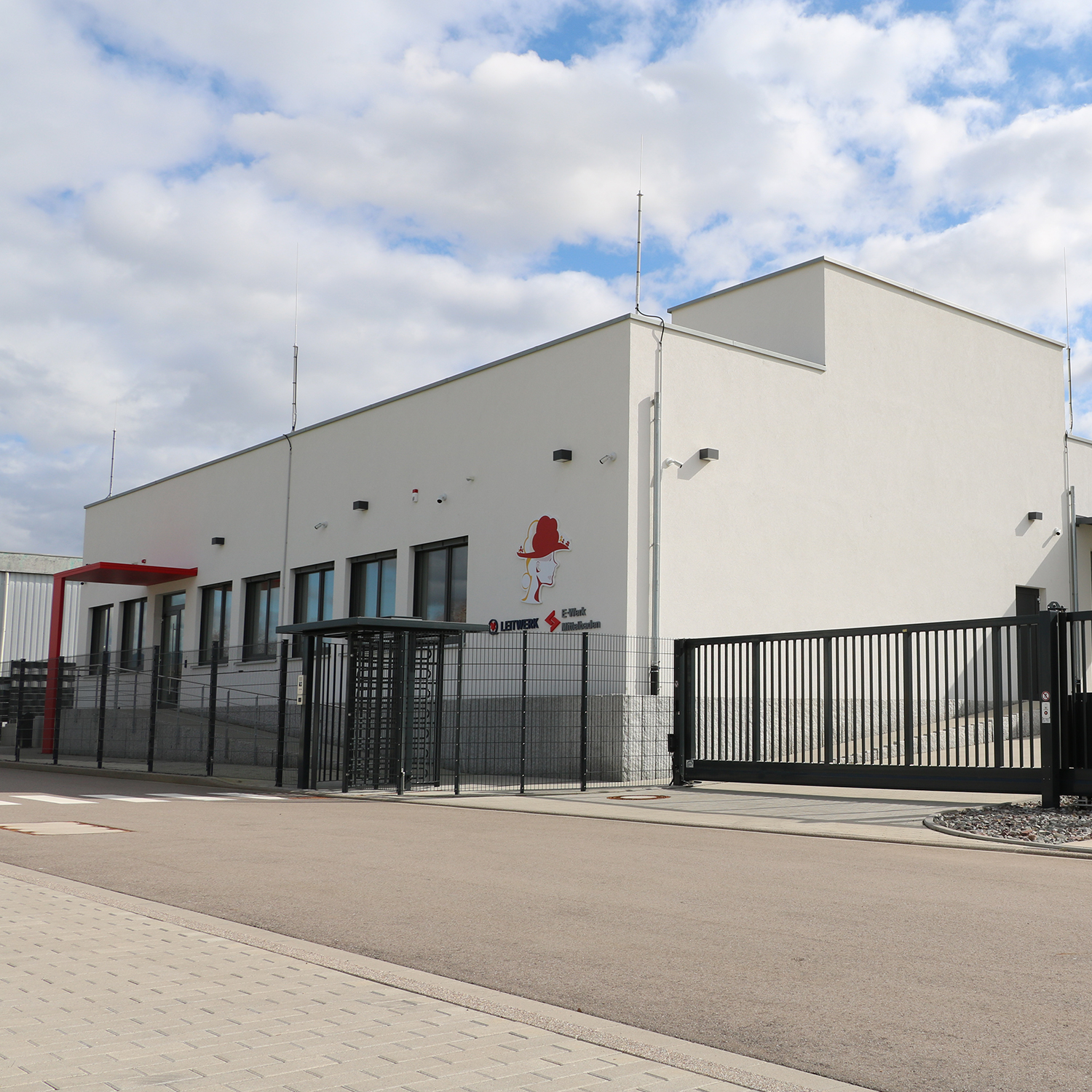 Foto Rechenzentrum Weißes umzäuntes Gebäude unter bewölktem Himmel